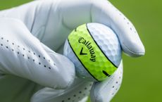 The Callaway Chrome Tour 360 being held in the hand of a golfer with a golf glove on, showing the Callaway logo and yellow 360 stripe on ball