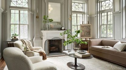 A living room in neutral colors with a coffee table in the centre and sofas around the edges