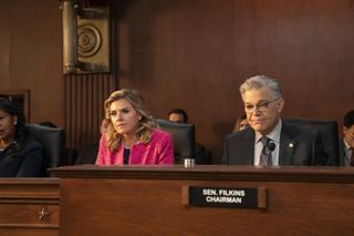 Eliza Coupe as Senator Margery Bay Bix and Al Franken as Senator Aaron Filkins sitting behind committee desks in the residence