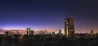 Saturn, Venus and Jupiter align above the skyline of Tel Aviv, Israel, as seen during the morning twilight.