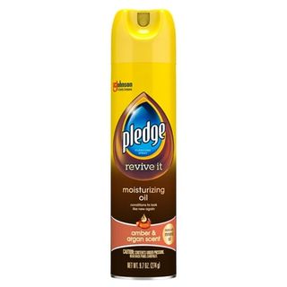 A yellow and brown spray bottle of Pledge Expert Care Wood Oil Furniture Polish, with blue logo