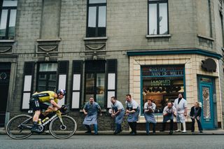 A cycle race past a butchers in Flanders