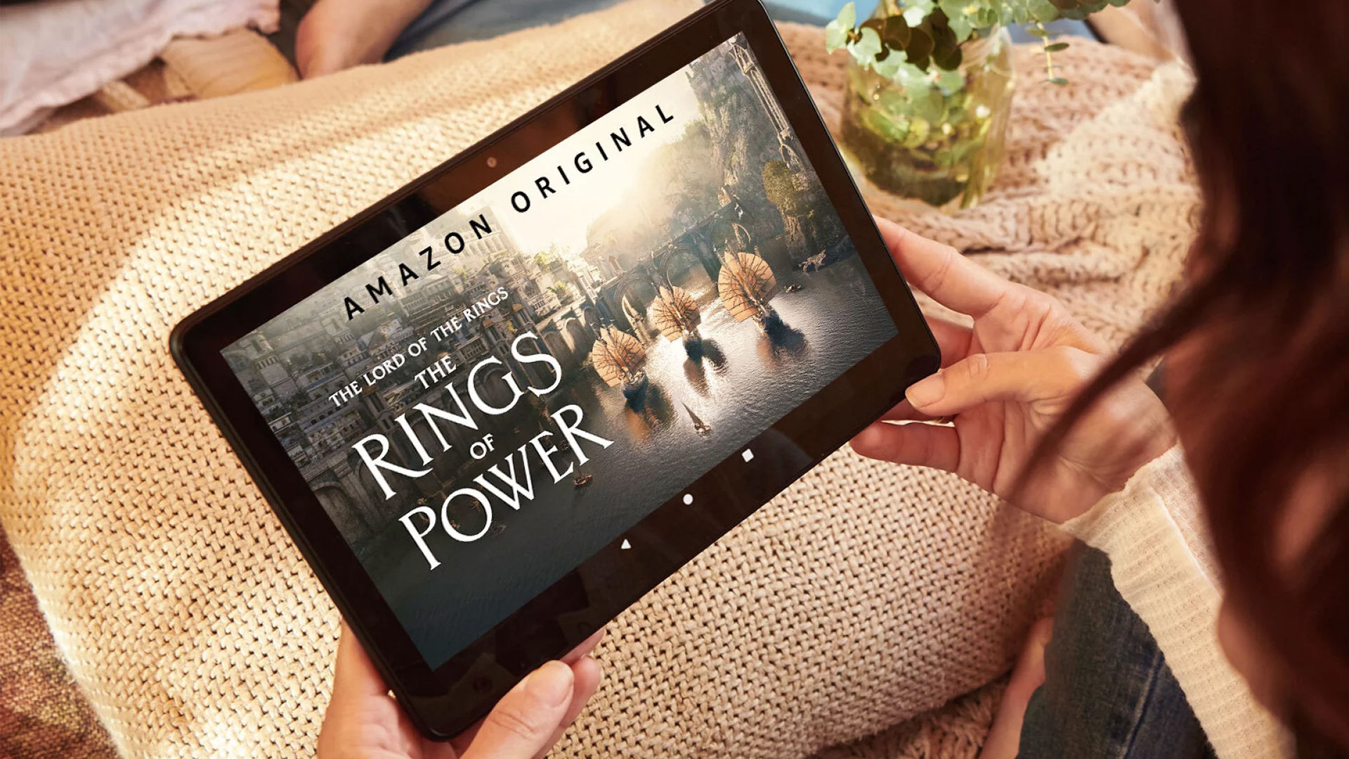 A woman holds a tablet with Prime Video on the screen