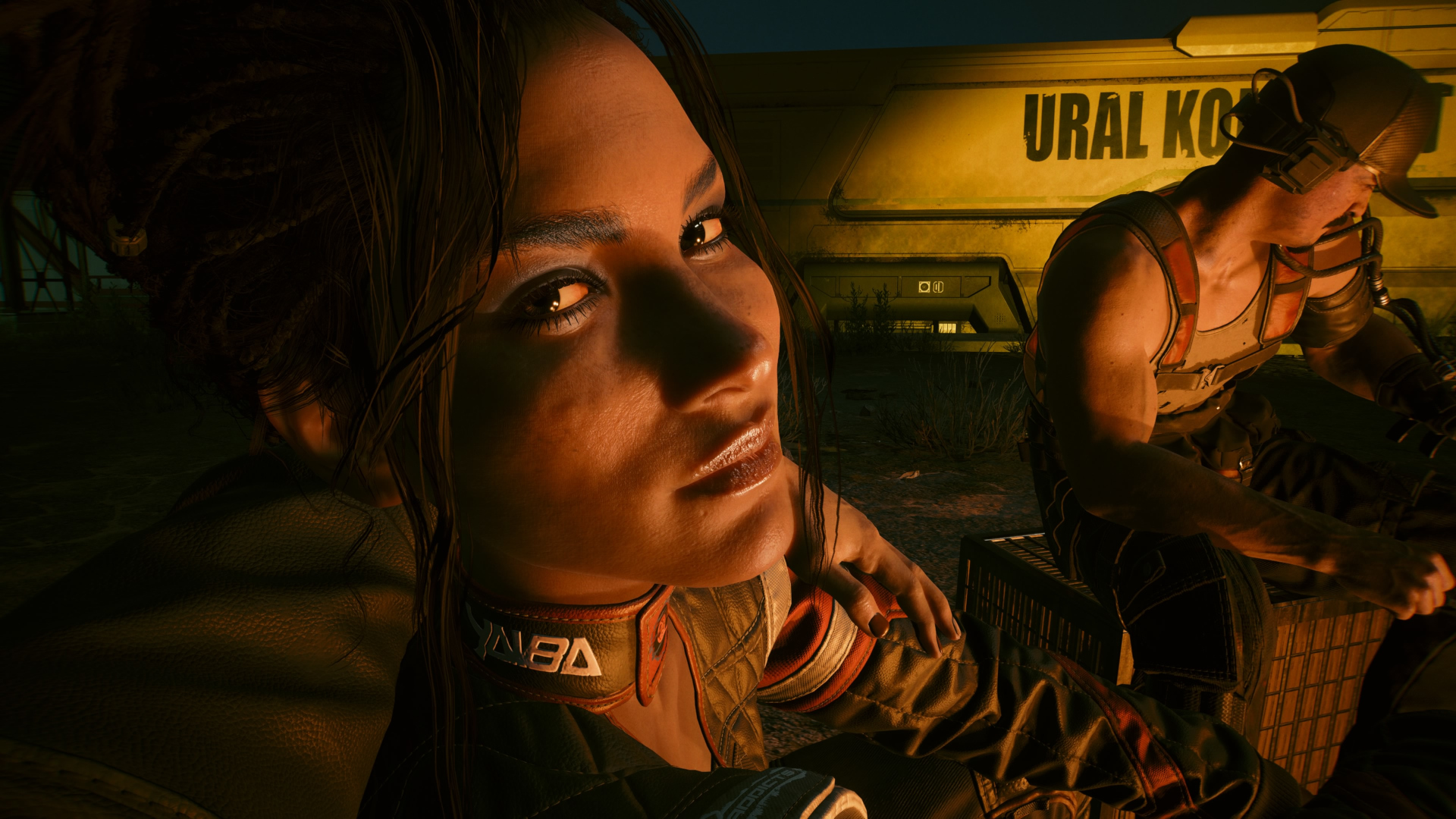 Panam looks at V as they sit around a fire with the Aldecaldos in Cyberpunk 2077