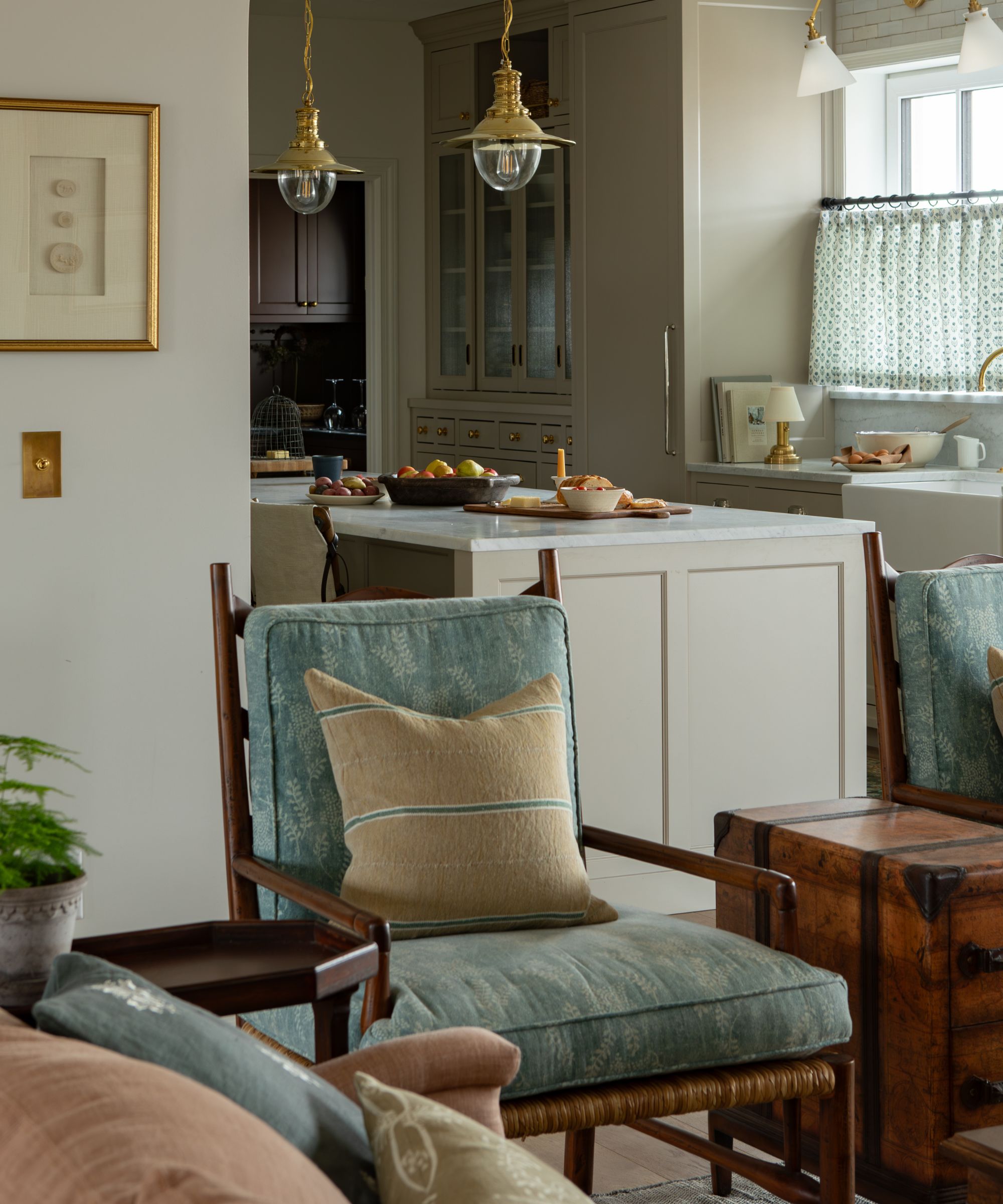 an open plan living room with an arched entryway into a neutral kitchen