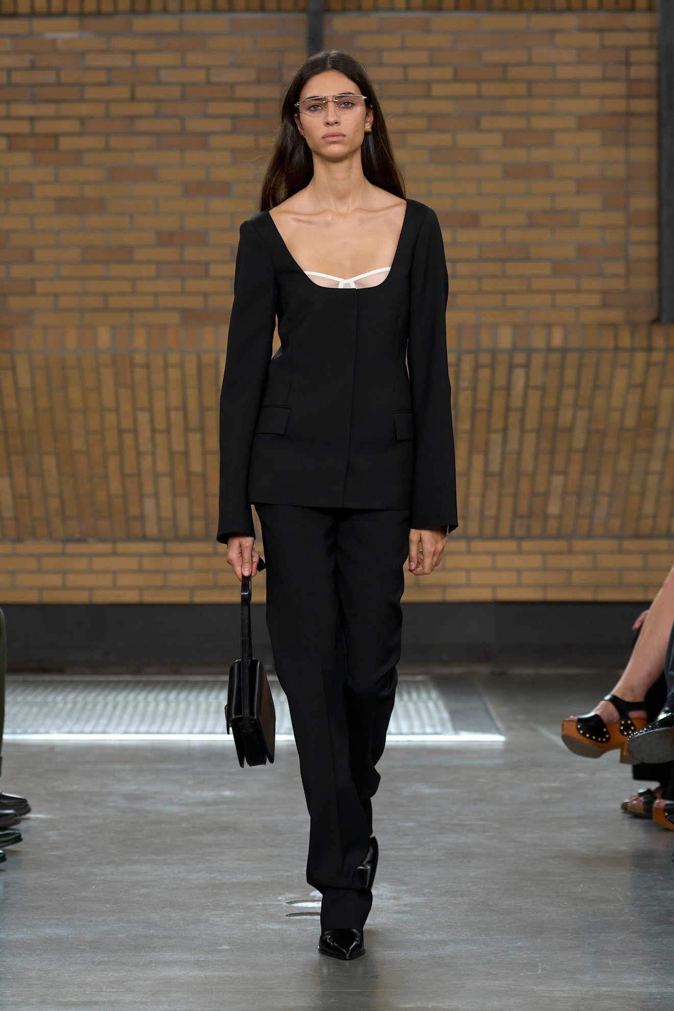 A model at the spring/summer 2026 Calvin Klein show wearing a scoopneck blazer with a peek-a-boo bra.
