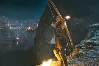 The sellsword Bronn prepares to send a fire arrow flying in the TV show Game of Thrones.