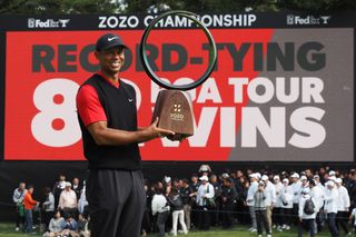 Tiger Woods holds the Zozo Championship trophy in 2019