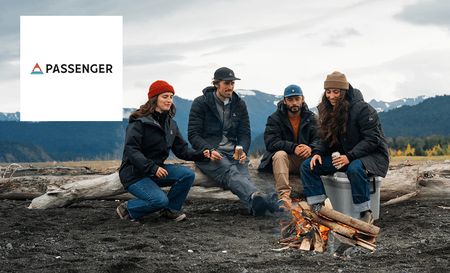 Passenger logo top left with a group of friends making a fire outdoors
