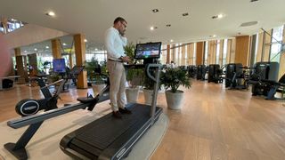 An expert talks through new features on a treadmill at the Technogym village