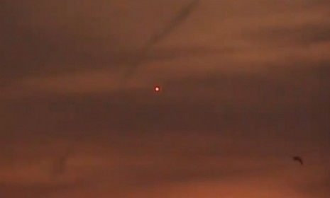 A glowing orb sits in the sunset sky over Lake Erie.