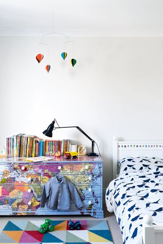 Kids bedroom with chest of drawers covered in maps