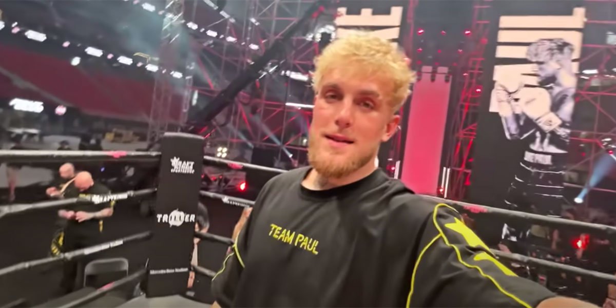 Jake Paul holding a camera inside a boxing ring with a Team Paul shirt on before his fight with Ben Askren.