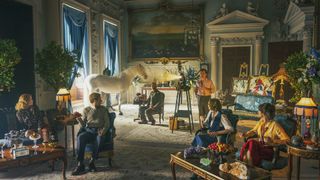 the pursuit of love cast sitting in a colorful room in a stately home