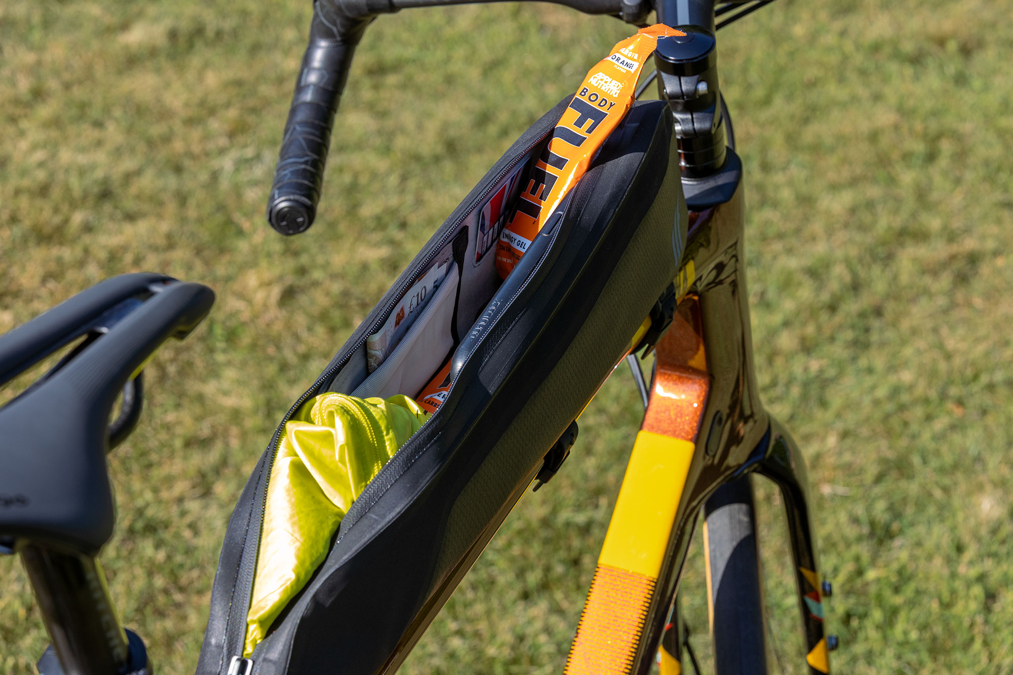 Tailfin Long Top Tube Bag showing interior loaded with phone, waterproof layer, cash and gels.