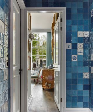 A blue tiled room with small drawings in individual tiles