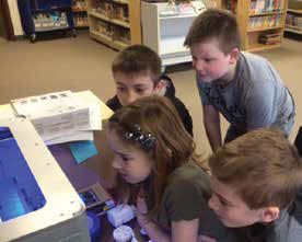 Sand Lake Elementary students, benefitting from Kent ISD services, watch a 3D printer print out their 3D models. 