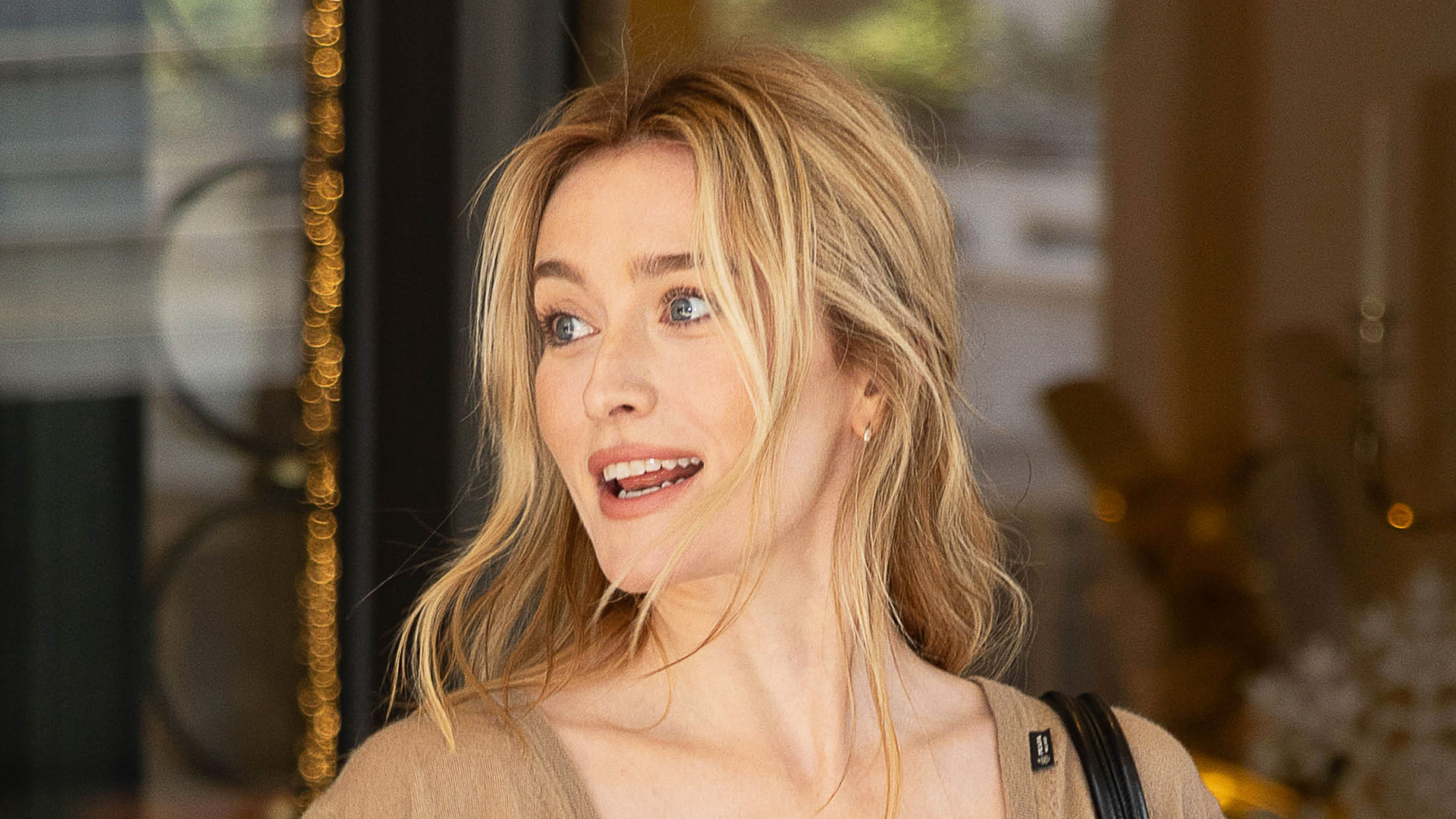 Sarah Pidgeon attending the Prada F/W 26 show during MFW wearing a an oatmeal-colored V-neck tank top and fringed butter yellow skirt with black pumps