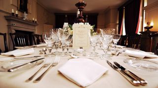 Menu and place settings at the long dinner table for the 80th birthday dinner for Queen Elizabeth II at Kew Palace