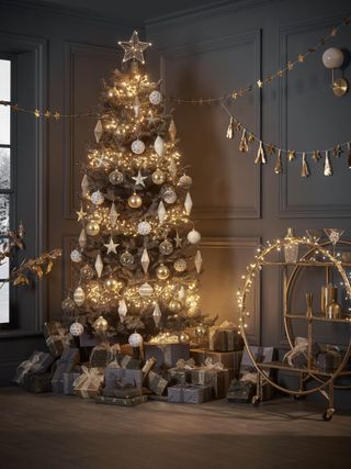 black Christmas tree with gold and white decorations, fairy lights and presents