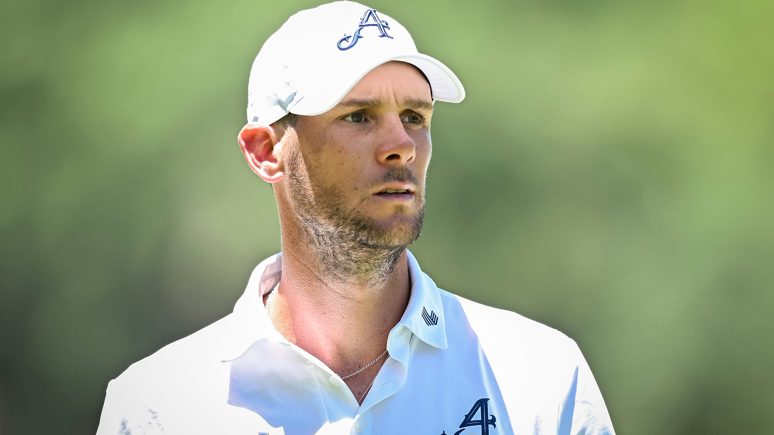 Thomas Pieters from the chest up wearing a white polo shirt and white cap during a LIV Golf tournament