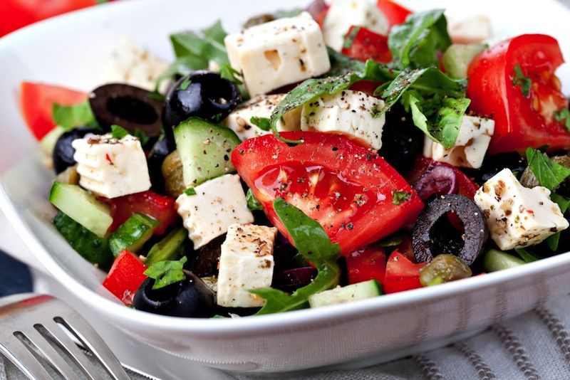 A salad with tomatoes, feta cheese and black olives