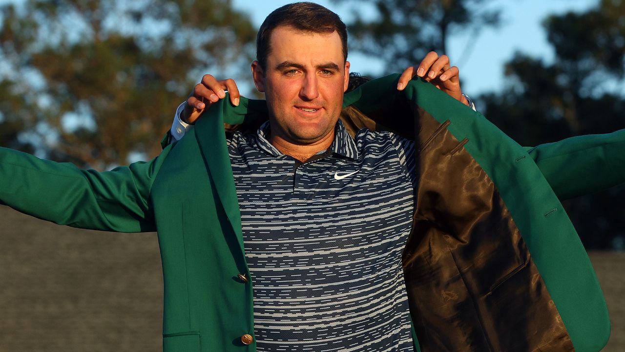 Scottie Scheffler is handed the Green Jacket after his 2022 Masters victory