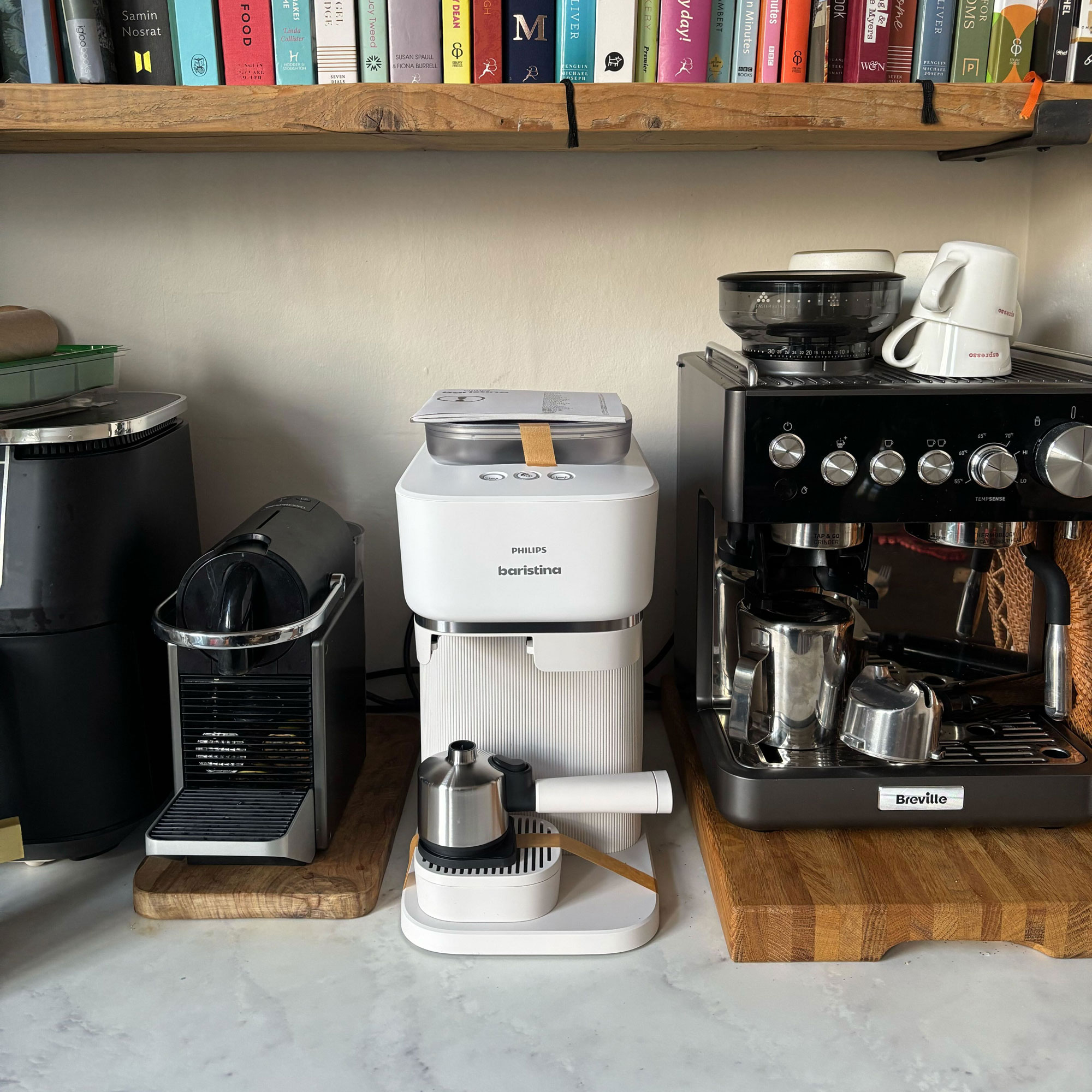 White White Philips Baristina next to two black coffee machinesBaristina