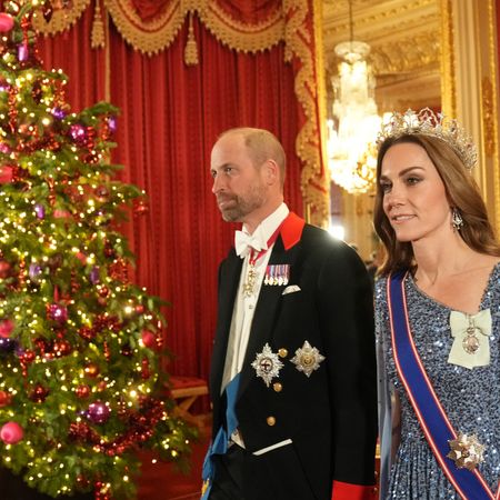 Prince William and Kate Middleton walk past a lit Christmas tree as they arrive at the state banquet for the German President Frank-Walter Steinmeier and his wife Elke Budenbender at Windsor Castle on December 3, 2025