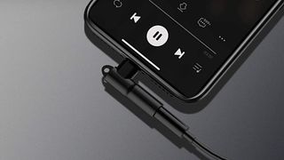 Mangotek Lightning To 3.5mm Headphone Adapter plugged into an iPhone.