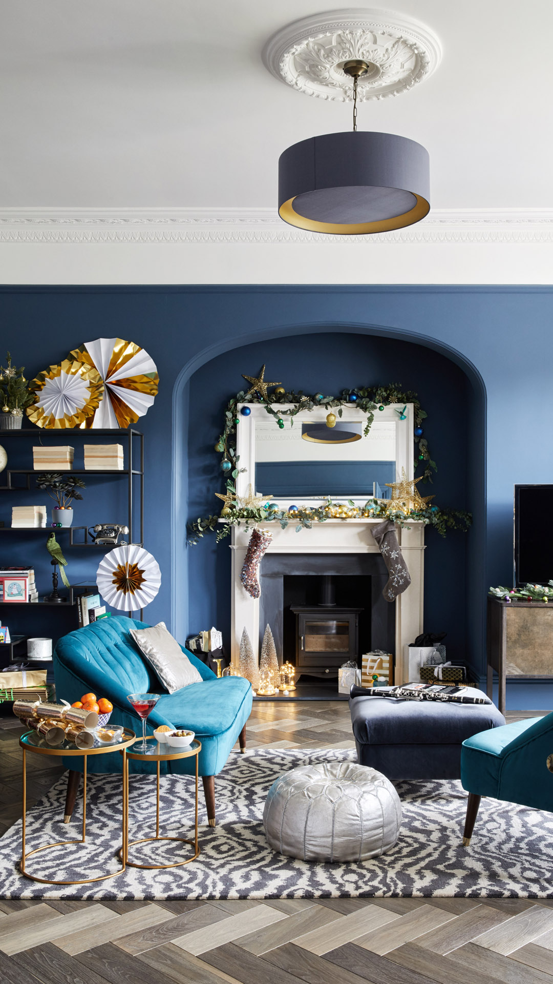 Blue wall living room blue sofa paper decorations Christmas Stockings fireplace mantel mantelpiece rug Christmas