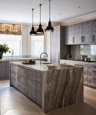 Unusually textured brown and gray cabinetry in a kitchen picture with pendant lighting, island and patterned blinds.