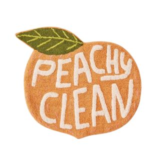 A peach-shaped bath mat that says 'peachy-clean'