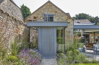 stone cottage with grey zinc porch extension