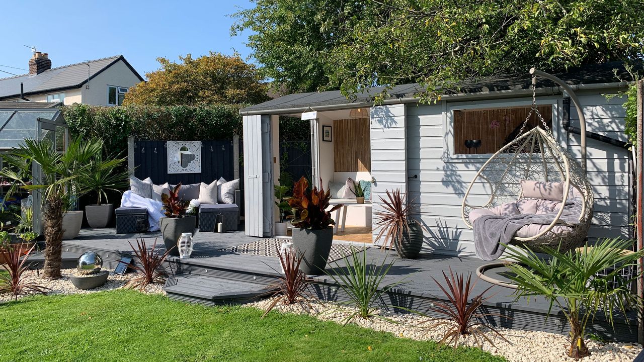 Garden shed on raised decking with hanging egg chair