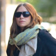 Ashley Olsen wearing jeans, slides, and carrying a rare alligator The Row bag