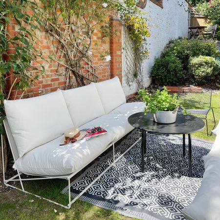 A sunny garden with two 3-seater IKEA HAVSTEN outdoor sofas facing each other