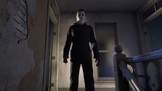 Michael Myers from Halloween stands in the shadows, looking scary