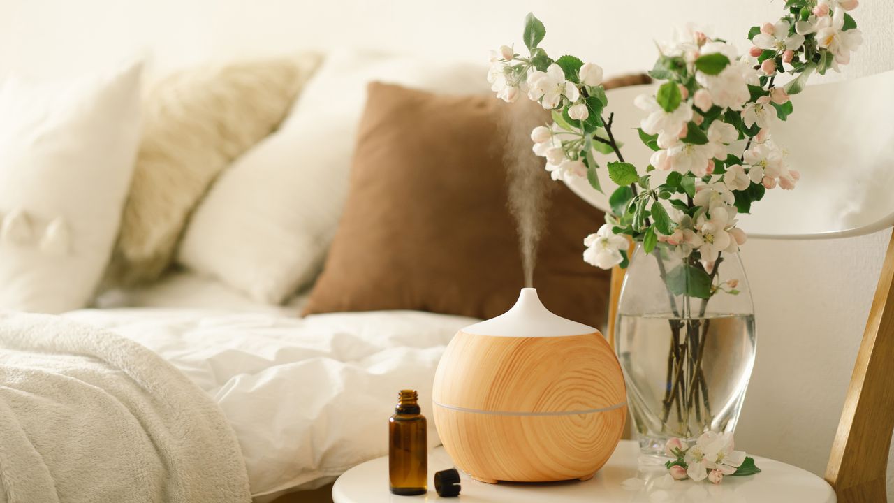 Aroma oil diffuser on chair against bed in the bedroom