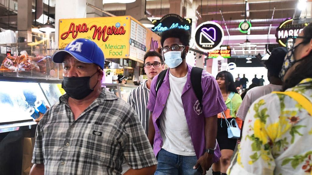 People walk inside a food hall in downtown Los Angeles.