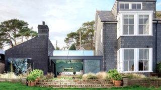 The exterior of a building with a new single storey side extension with a glass link