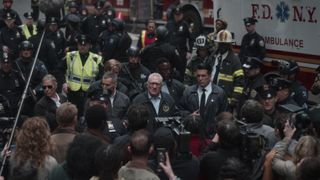 Robert De Niro as George Mullen addressing a crowd and reporters, with police and firefighters in the background.