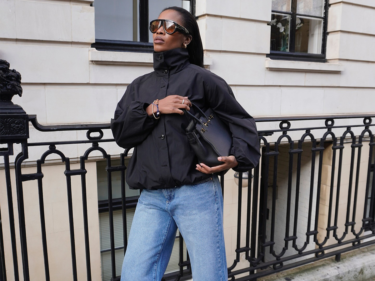 Influencer Marilyn wears a funnel-neck jacket with raw hem light-wash jeans and black leather boots.