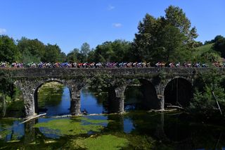 The peloton crosses a bridge early on stage 11