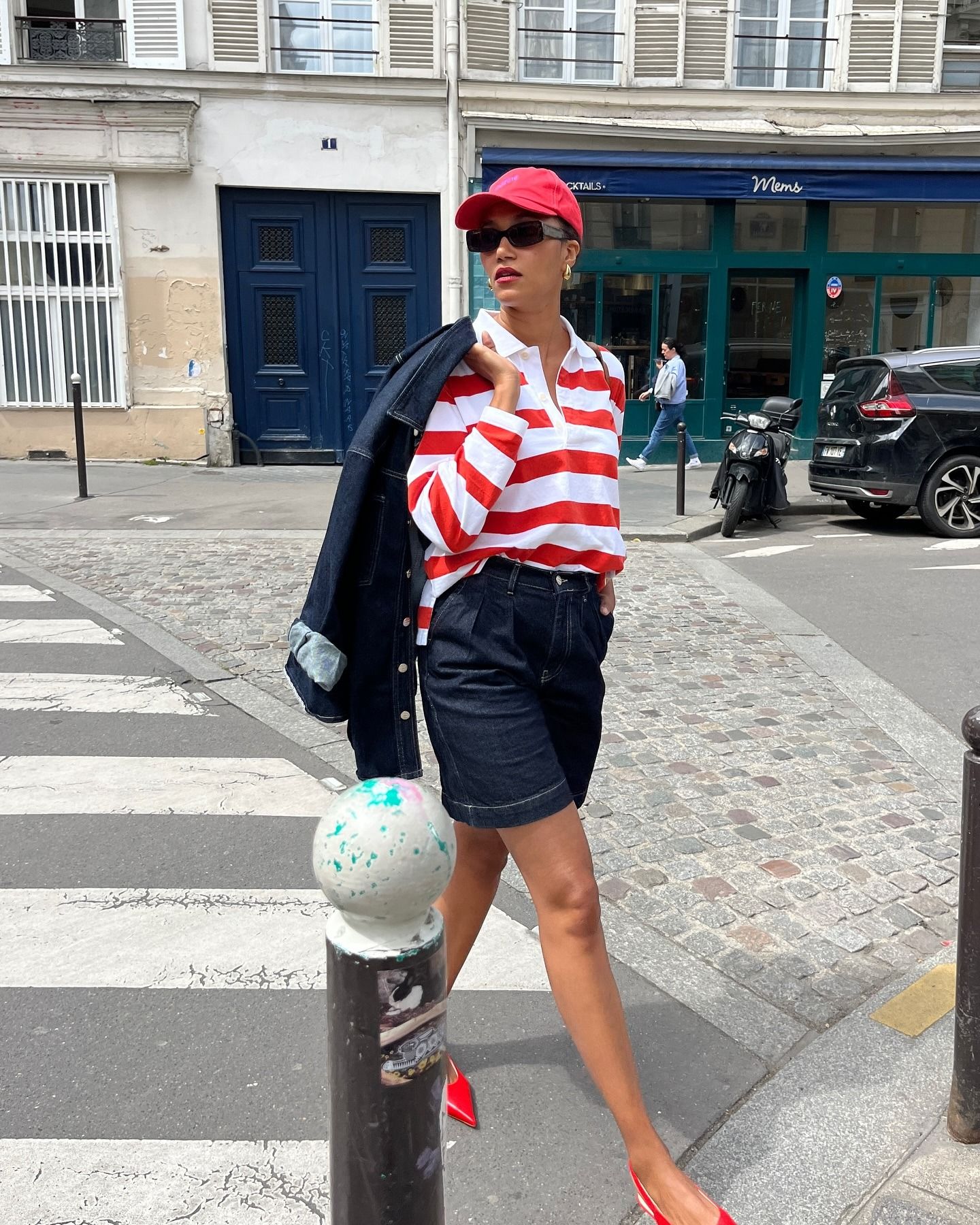 Woman wearing long denim bermuda short.