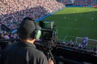 Shot of a man shooting a MLS match with an iPhone on a production rig. 