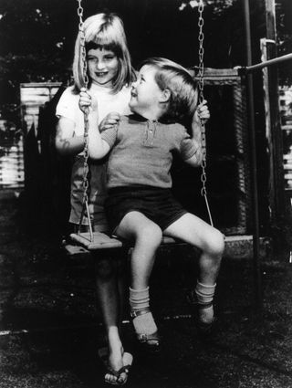 A black-and-white picture of Princess Diana pushing Charles Spencer on a swing as a child