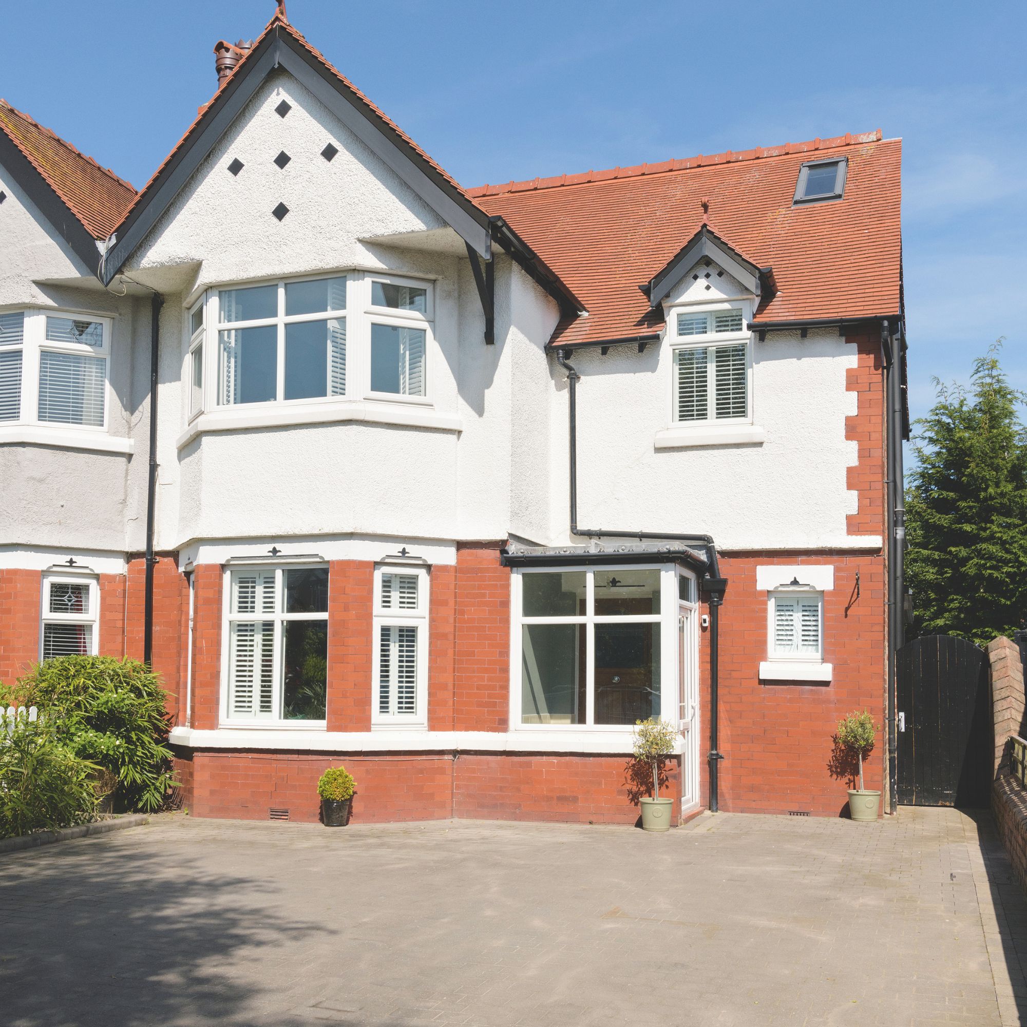 Driveway of semi-detached home with brick and render facade
