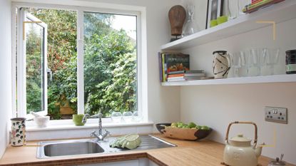 White kitchen with window open behind the sink to support a guide that highlights how to get rid of flying ants that enter through windows