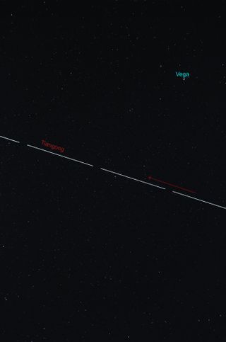 streak of white light across the sky is the tiangong space station beneath Vega.